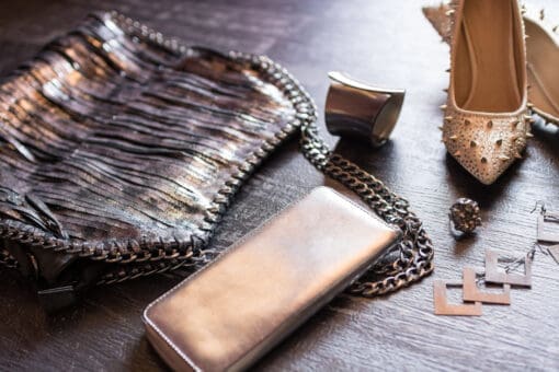 Closeup top view image of fashionable women's bag and shoes aside accessories on a dark wooden background